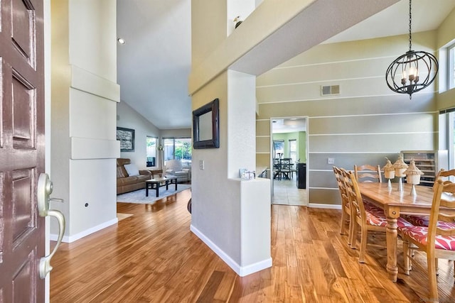 interior space featuring light hardwood / wood-style floors, high vaulted ceiling, and a notable chandelier