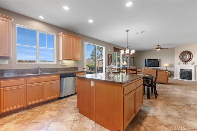 kitchen with ceiling fan with notable chandelier, pendant lighting, dishwasher, sink, and a center island with sink