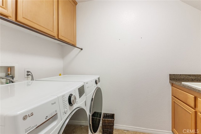 washroom with cabinets and washing machine and dryer