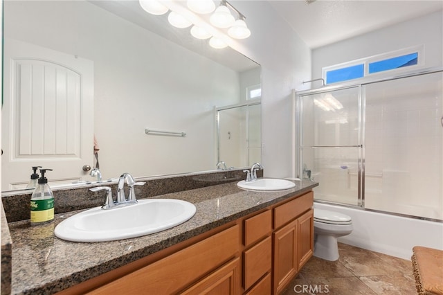 full bathroom with toilet, vanity, and shower / bath combination with glass door