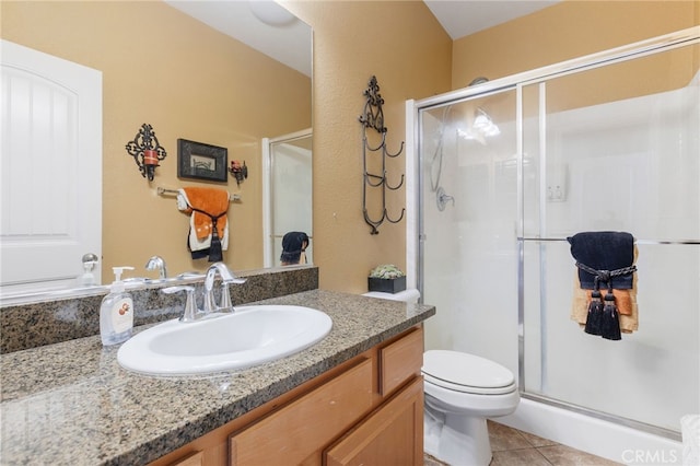 bathroom with an enclosed shower, vanity, and tile patterned flooring