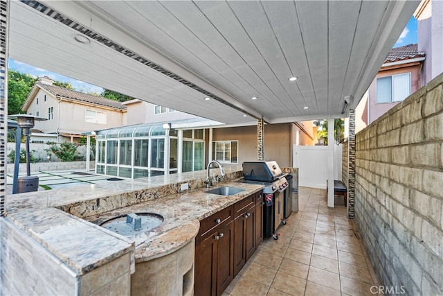 view of patio / terrace with a pool, area for grilling, sink, and grilling area