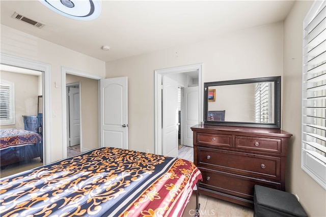 bedroom with light wood-type flooring and multiple windows