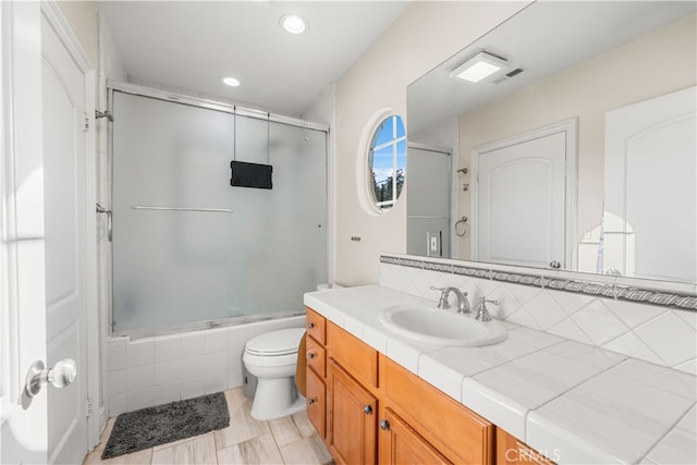 full bathroom with vanity, tile patterned flooring, toilet, and combined bath / shower with glass door