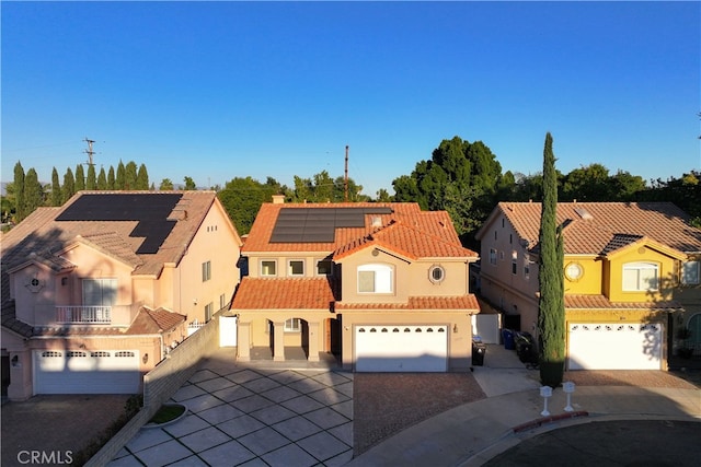 mediterranean / spanish-style home with a garage and solar panels