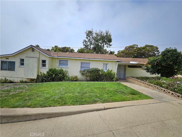 single story home featuring a front lawn