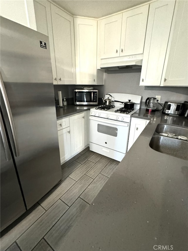 kitchen with stainless steel appliances, sink, and white cabinetry