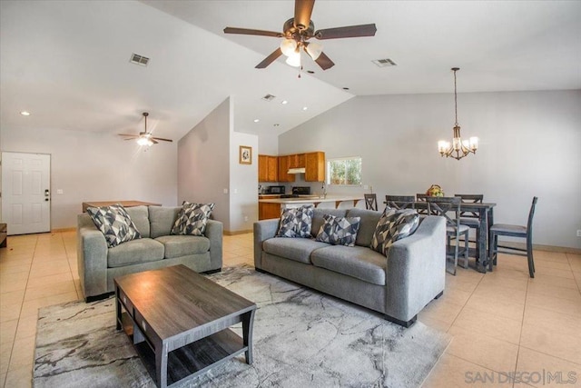 living room with ceiling fan with notable chandelier, vaulted ceiling, and light tile patterned floors