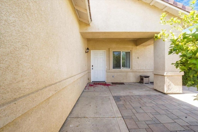 view of exterior entry featuring a patio area