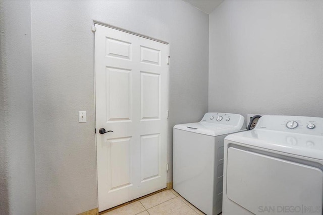 clothes washing area featuring washer and dryer and light tile patterned floors