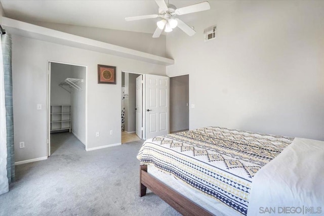 carpeted bedroom with lofted ceiling, a closet, a walk in closet, and ceiling fan