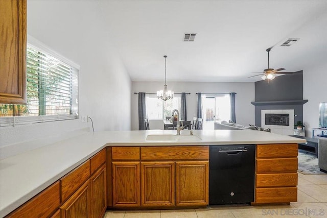 kitchen with a tiled fireplace, decorative light fixtures, sink, dishwasher, and light tile patterned floors