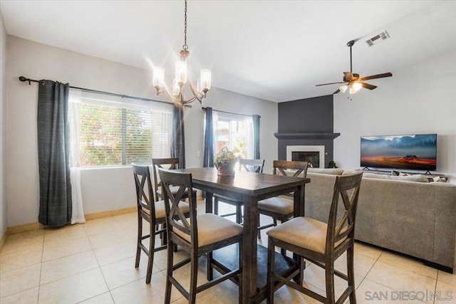 dining space featuring ceiling fan with notable chandelier and light tile patterned floors