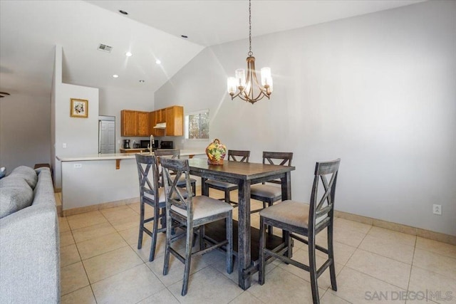 dining room featuring light tile patterned floors, a chandelier, and vaulted ceiling