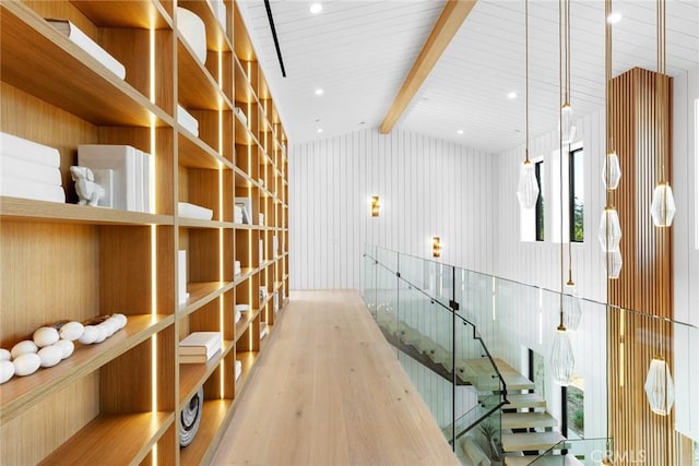 wine room with vaulted ceiling with beams, wood walls, and wood-type flooring