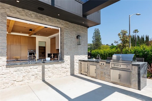 view of patio featuring sink, a grill, and exterior kitchen