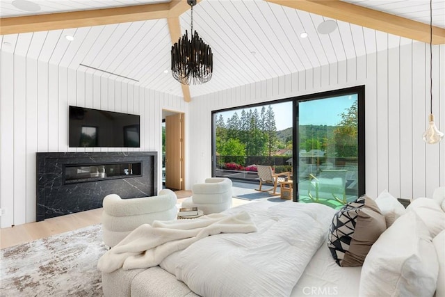 bedroom with a fireplace, hardwood / wood-style floors, access to outside, and wooden walls