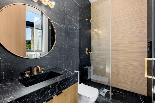 bathroom with tiled shower, vanity, toilet, and tile walls