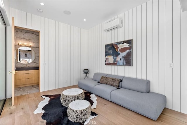 living room featuring hardwood / wood-style flooring, an AC wall unit, and wood walls