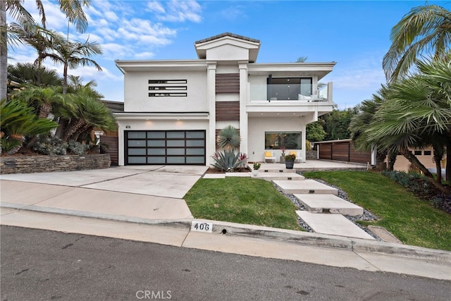 modern home with a balcony, a front lawn, and a garage