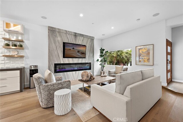 living room featuring a large fireplace and light wood-type flooring