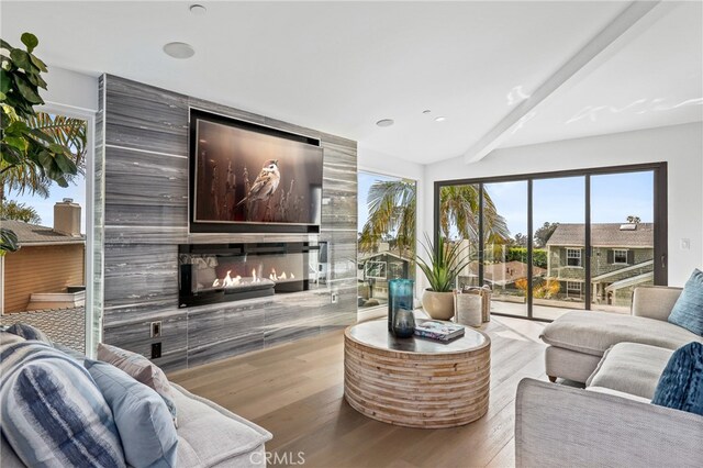 living room featuring beamed ceiling and light hardwood / wood-style flooring