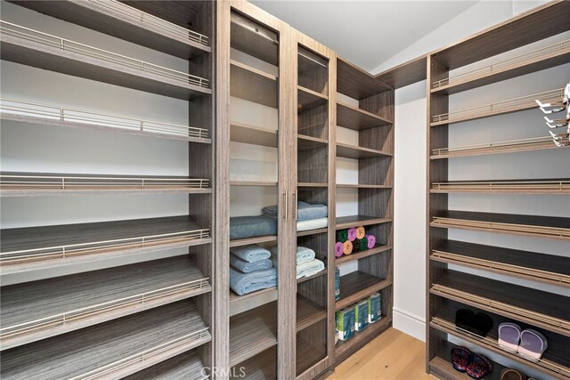 walk in closet with light hardwood / wood-style flooring