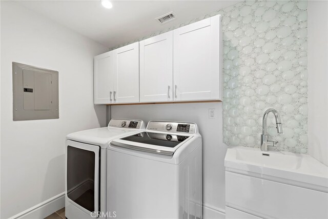 laundry area with sink, electric panel, independent washer and dryer, and cabinets