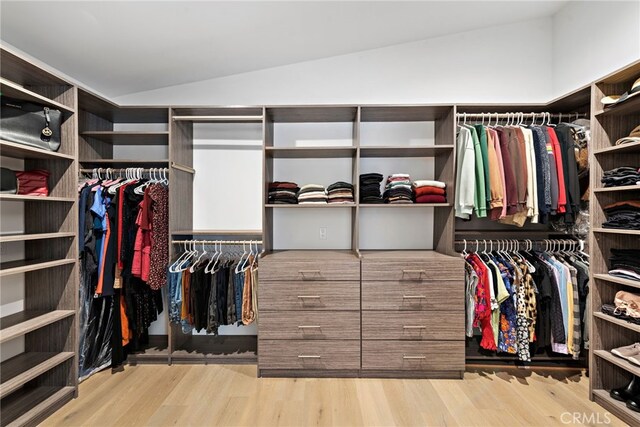 walk in closet featuring vaulted ceiling and light hardwood / wood-style flooring