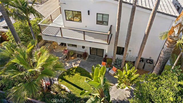 rear view of property featuring a patio, ac unit, and a balcony