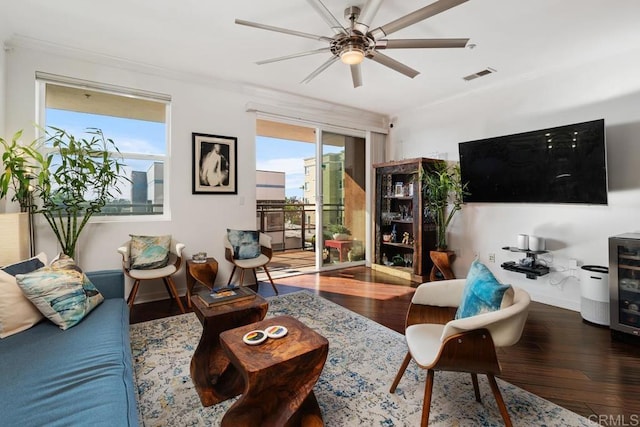 living room with wood-type flooring, wine cooler, ornamental molding, and ceiling fan