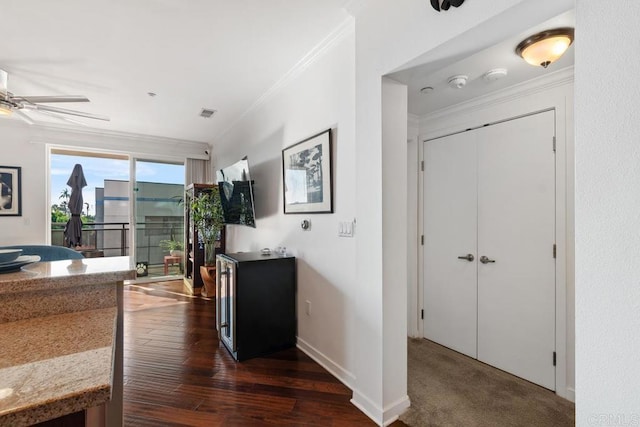 interior space with ceiling fan, crown molding, and dark wood-type flooring