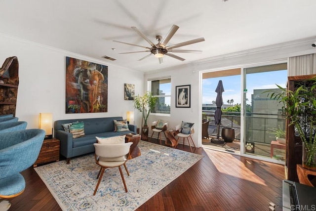 living room featuring ceiling fan, crown molding, and dark wood-type flooring