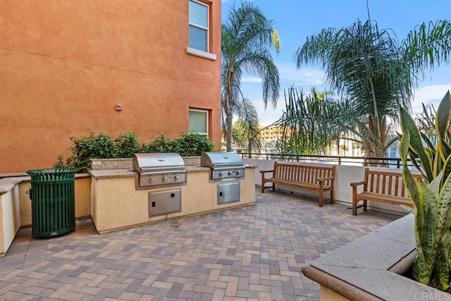 view of patio featuring an outdoor kitchen and a grill