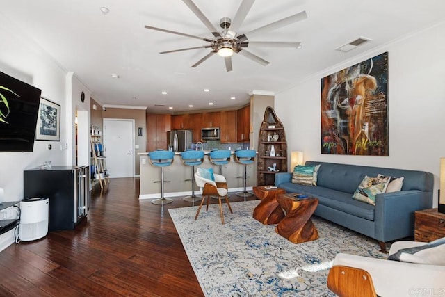 living room with ceiling fan, ornamental molding, and dark wood-type flooring