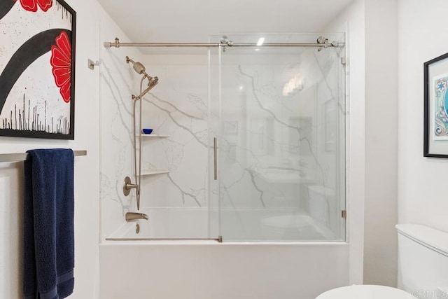 bathroom with shower / bath combination with glass door and toilet