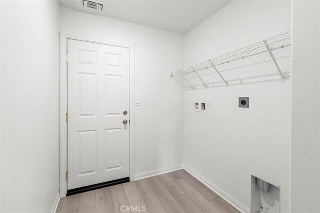 washroom with washer hookup, electric dryer hookup, and light hardwood / wood-style floors