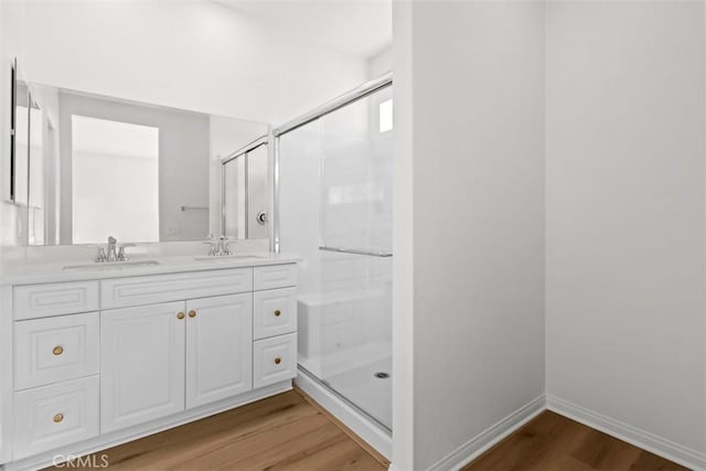 bathroom featuring a shower with shower door, wood-type flooring, and vanity