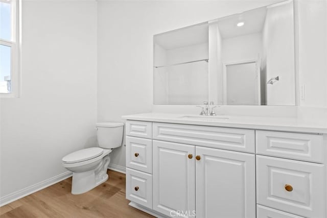 bathroom featuring wood-type flooring, toilet, and vanity