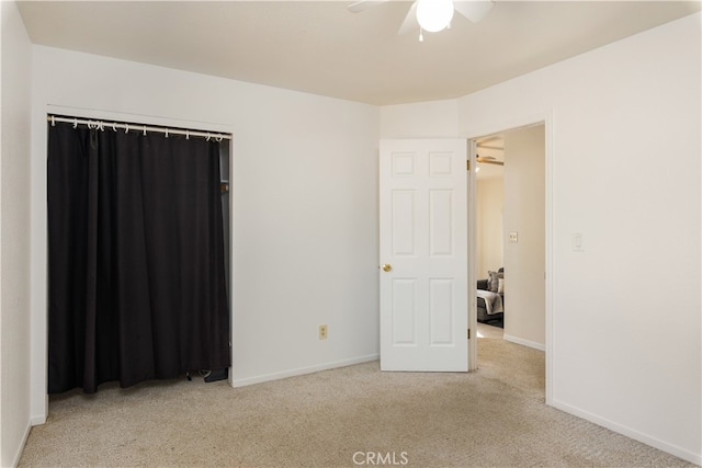 spare room with ceiling fan and light colored carpet