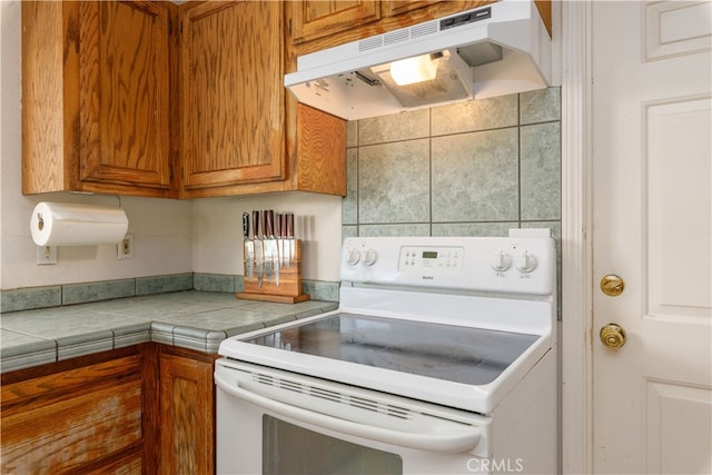 kitchen with tile counters and white range with electric cooktop