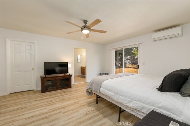 bedroom featuring access to exterior, ceiling fan, ensuite bathroom, light hardwood / wood-style flooring, and a wall mounted air conditioner