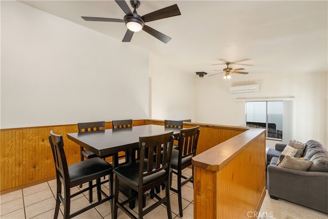 dining area featuring wood walls, ceiling fan, light tile patterned flooring, and a wall mounted AC