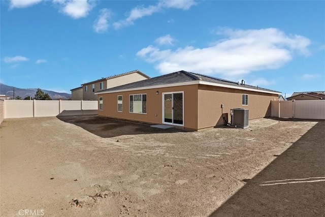 rear view of property featuring a mountain view and central AC unit