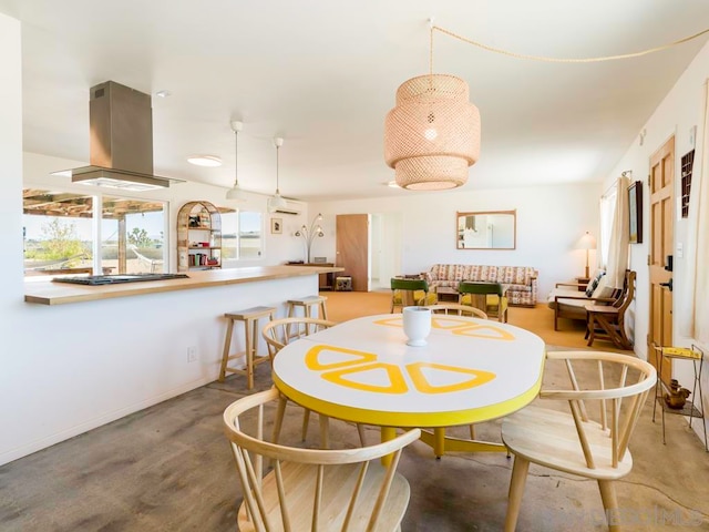 dining room with concrete flooring and an AC wall unit