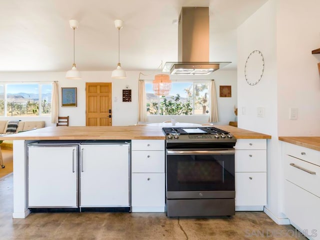 kitchen with white refrigerator, wood counters, stainless steel stove, island exhaust hood, and hanging light fixtures