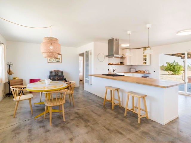 kitchen with pendant lighting, a kitchen bar, kitchen peninsula, and extractor fan