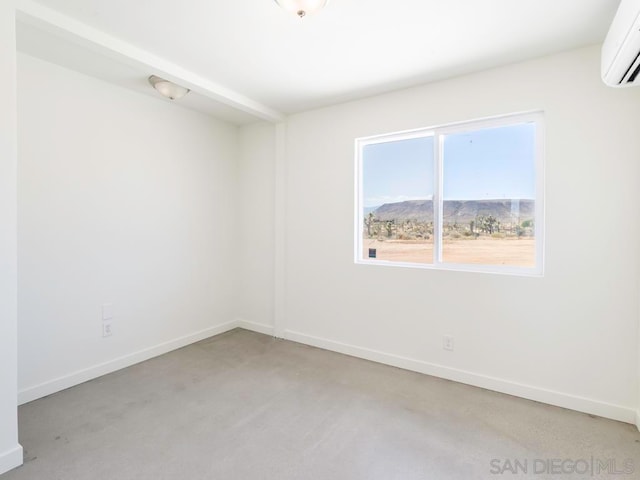 empty room featuring light carpet, a mountain view, and a wall mounted air conditioner