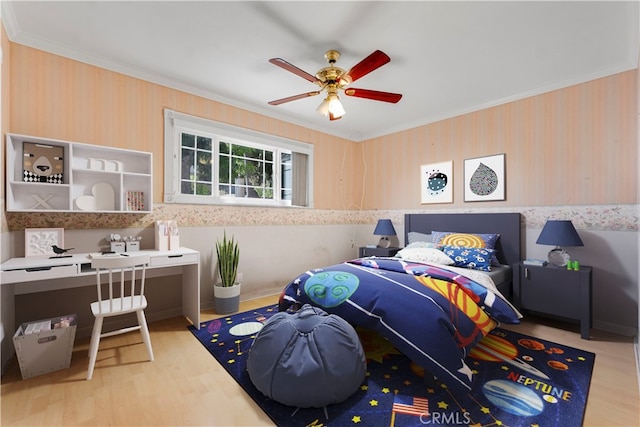 bedroom with light wood-type flooring, crown molding, and ceiling fan