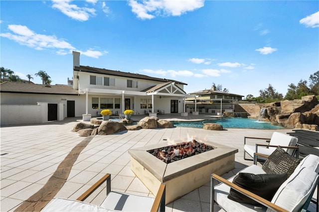 exterior space featuring a fire pit, a patio, and pool water feature